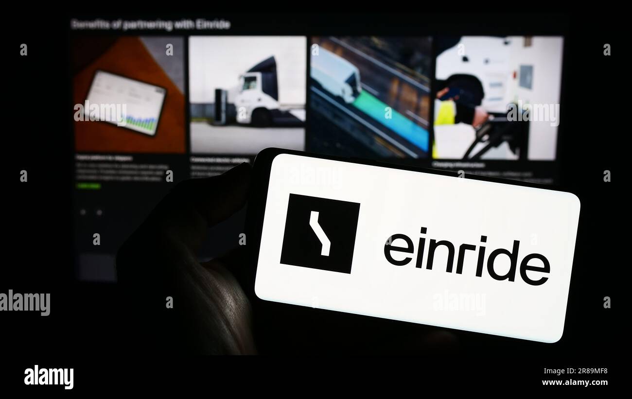 Persona in possesso di un cellulare con il logo della società svedese di mobilità elettrica Einride AB sullo schermo di fronte alla pagina web. Concentrarsi sul display del telefono. Foto Stock