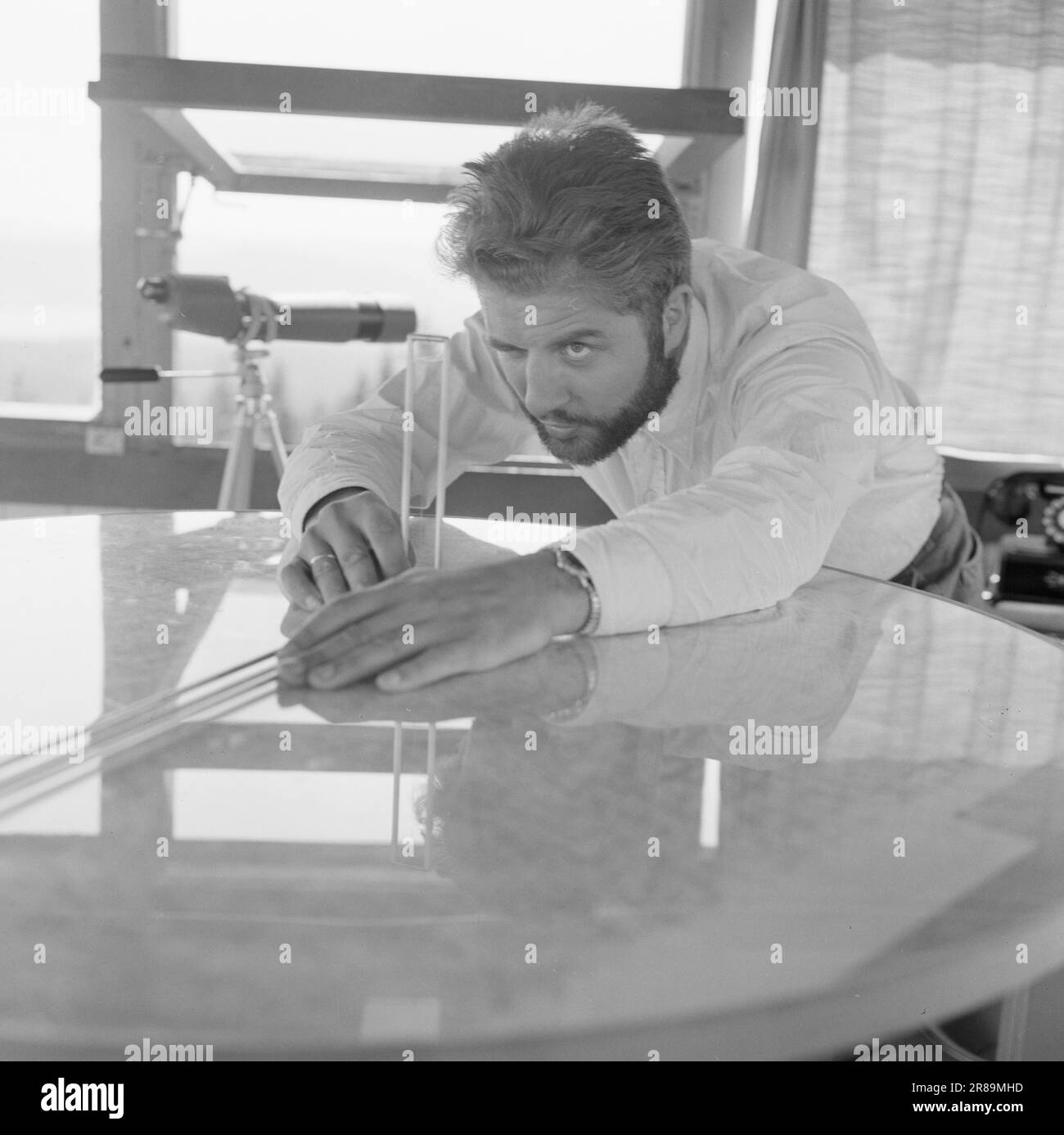 Attuale 29-6-1960: La sentinella solitaria abbiamo trovato un posto di lavoro strano. Giù là, un uomo che vive al suo posto cammina. Giorno e notte il nemico si aggirano, giorno e notte l'uomo solitario è in guardia - contro il fuoco della foresta. Stein Aanderaa, uno studente di teologia, ha un lavoro solitario di vacanza nella torre di guardia antincendio di Skgennungsåsen nelle foreste di Oslo. Alto e libero sopra le cime degli alberi, egli custodisce 5 miglia di foresta in tutte le direzioni. Al centro del pavimento nella sala di guardia, ha un tavolo con mappe e un dispositivo sonoro. È in servizio 24 ore su 24. Foto: Aage Storløkken / Aktuell / NTB ***FOTO NON IMA Foto Stock