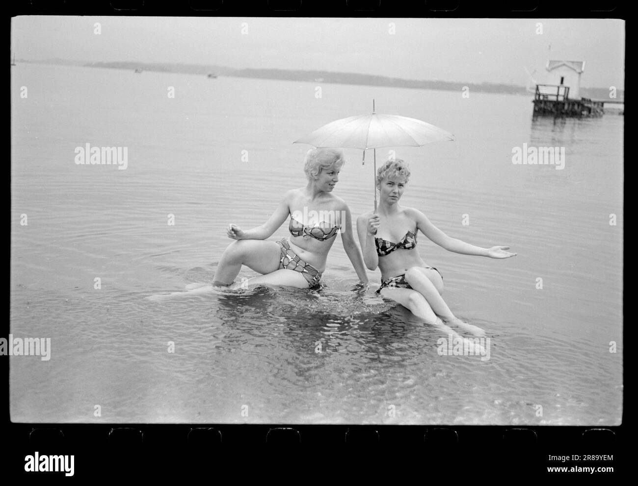 Attuale 33-5-1960: Marrone senza sole ora una nuova preparazione è disponibile per l'acquisto qui in Norvegia - un liquido che si striscio su in modo che si ottiene un abbronzatura durante la notte. Abbiamo fatto un esperimento e potete studiare i risultati nelle immagini. Dopo otto ore, la Marit oliata era dorata, ma aggiungiamo che si è rivelata un'abbronzatura costosa. Per il trattamento sono state utilizzate circa tre bottiglie, ciascuna delle quali costa 12 NOK. Era gocciolante e il sole era lontano dalle nuvole quando il primo cappotto fu posato alle 12. Marit (a sinistra) la voltò di nuovo a Brittan e la lasciò sola. Se la panacea mantenesse la sua promessa Foto Stock