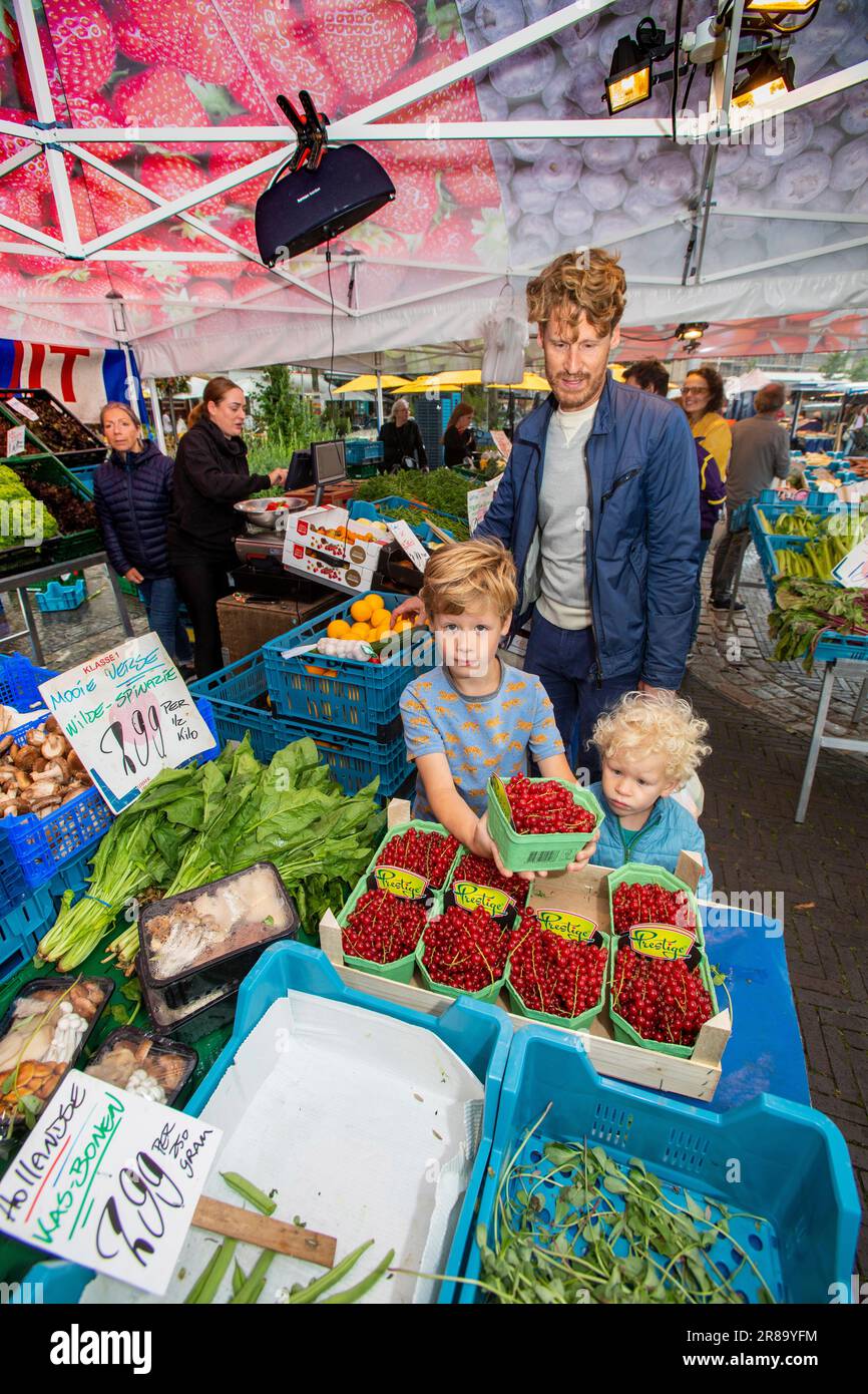 Paesi Bassi, padre e figli sul mercato in una stalla di frutta e verdura. Foto Stock