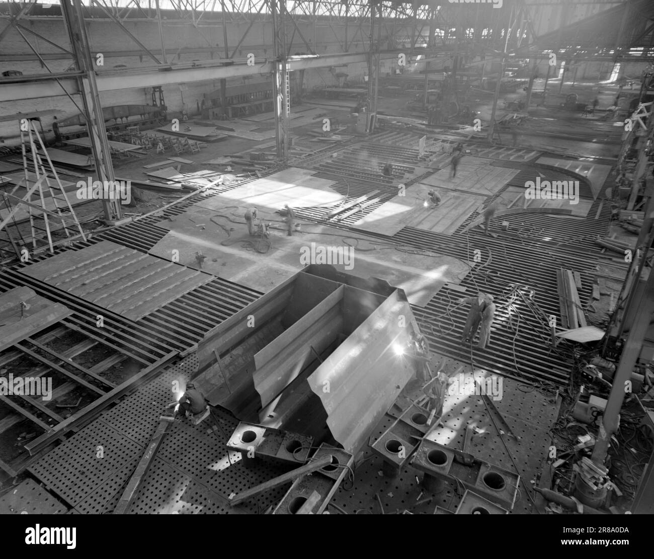 Corrente 21-4-1950: Rosenberg: Un'avventura tecnicaIn un angolo infernale, la saldatura difettosa può essere abbastanza fatale. L'officina meccanica di Rosenberg prende raggi X delle barche che costruiscono prima di rilasciarle negli oceani del mondo. Dopo la guerra hanno avuto una violenta espansione, e sono ora senza dubbio i più moderni della Norvegia nel loro genere. La sala del grande stabilimento navale si estende su 11 ettari. È qui che vengono create le singole parti dell'imbarcazione. Vi sono pacchi pesanti che vengono lavorati nel settore della cantieristica navale, ed è quindi ben equipaggiato con gru e carrelli. Quando le piastre Foto Stock