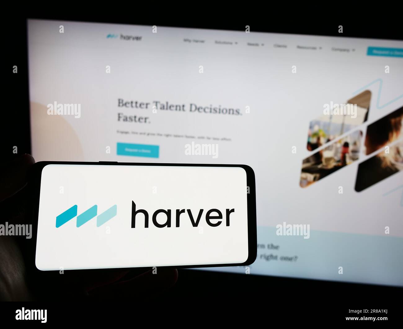 Persona che possiede uno smartphone con il logo della società di gestione dei talenti Harver B.V. sullo schermo di fronte al sito Web. Concentrarsi sul display del telefono. Foto Stock