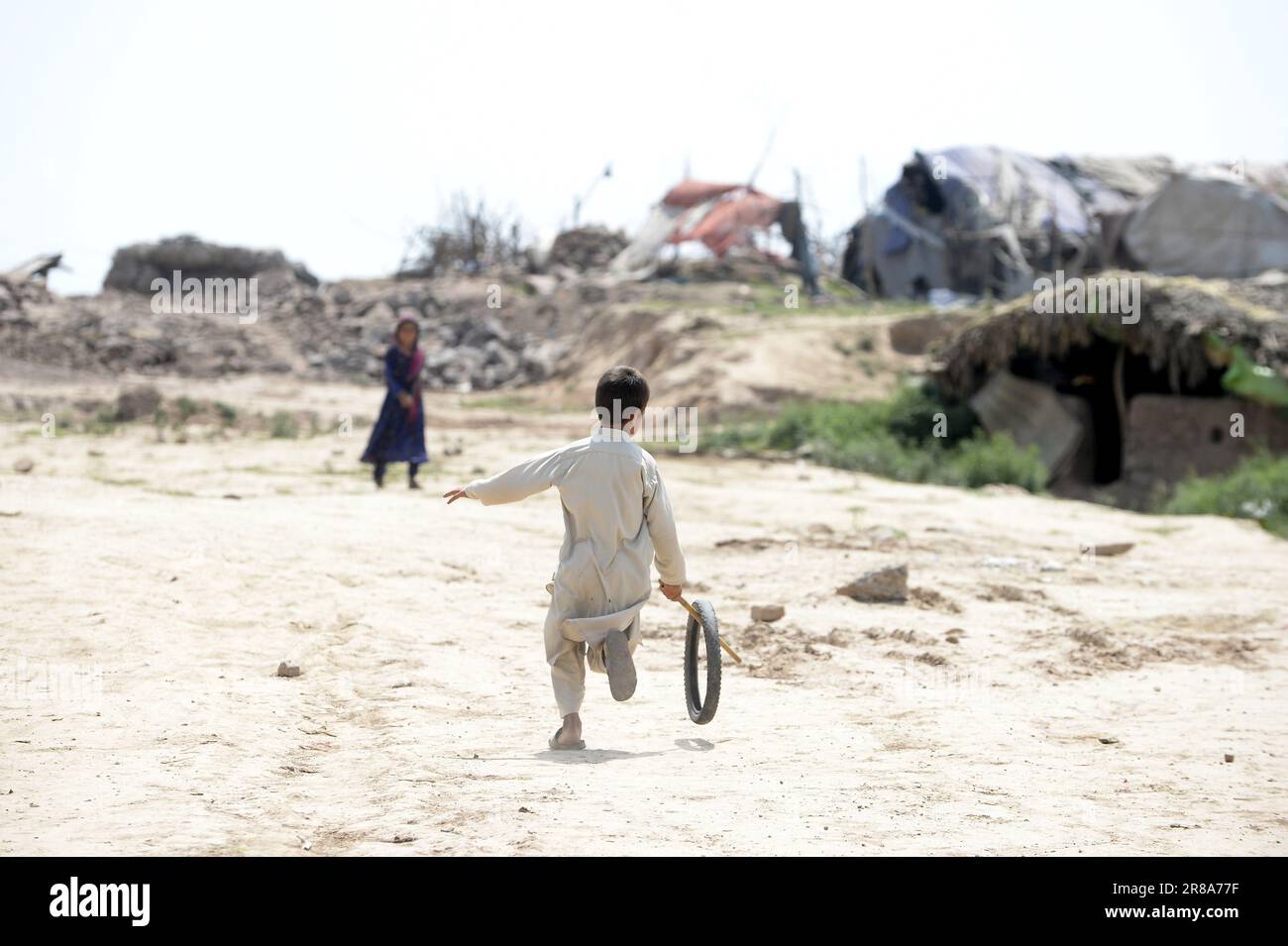 (230620) -- ISLAMABAD, 20 giugno 2023 (Xinhua) -- Un ragazzo gioca con un pneumatico in un campo profughi nella Giornata Mondiale del Rifugiato a Islamabad, Pakistan, il 20 giugno 2023. Il presidente pakistano Arif Alvi ha detto che il suo paese ha continuato ad ospitare una delle più grandi popolazioni di rifugiati del mondo, mostrando la determinazione e l'impegno inscevri del Pakistan per il benessere e il rimpatrio volontario dei rifugiati. Nel suo messaggio in occasione della Giornata Mondiale del Rifugiato che si celebra martedì, Alvi ha detto che "in quel giorno, ci viene ricordato l'immenso contributo del governo e della popolazione pakistana nell'ospitare milioni di persone Foto Stock