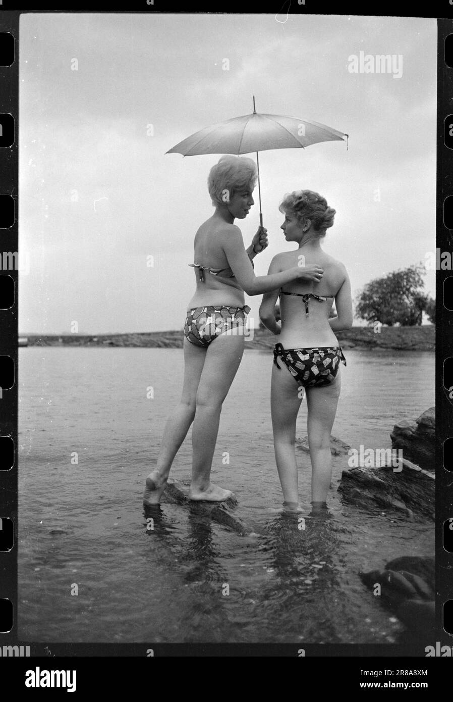 Attuale 33-5-1960: Marrone senza sole ora una nuova preparazione è disponibile per l'acquisto qui in Norvegia - un liquido che si striscio su in modo che si ottiene un abbronzatura durante la notte. Abbiamo fatto un esperimento e potete studiare i risultati nelle immagini. Dopo otto ore, la Marit oliata era dorata, ma aggiungiamo che si è rivelata un'abbronzatura costosa. Per il trattamento sono state utilizzate circa tre bottiglie, ciascuna delle quali costa 12 NOK. Era gocciolante e il sole era lontano dalle nuvole quando il primo cappotto fu posato alle 12. Marit (a sinistra) la voltò di nuovo a Brittan e la lasciò sola. Se la panacea mantenesse la sua promessa Foto Stock