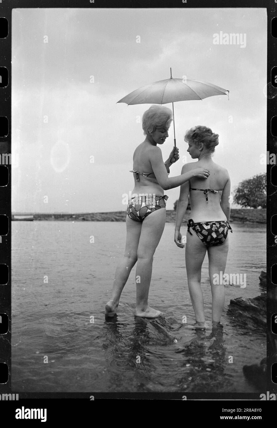 Attuale 33-5-1960: Marrone senza sole ora una nuova preparazione è disponibile per l'acquisto qui in Norvegia - un liquido che si striscio su in modo che si ottiene un abbronzatura durante la notte. Abbiamo fatto un esperimento e potete studiare i risultati nelle immagini. Dopo otto ore, la Marit oliata era dorata, ma aggiungiamo che si è rivelata un'abbronzatura costosa. Per il trattamento sono state utilizzate circa tre bottiglie, ciascuna delle quali costa 12 NOK. Era gocciolante e il sole era lontano dalle nuvole quando il primo cappotto fu posato alle 12. Marit (a sinistra) la voltò di nuovo a Brittan e la lasciò sola. Se la panacea mantenesse la sua promessa Foto Stock