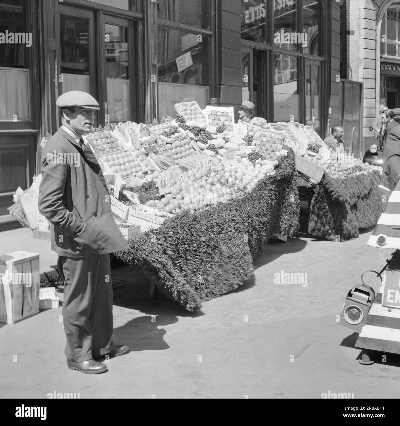 12-1951: Incontro con LondonEditor per Bratland in un viaggio di reportage a Londra per coprire il 'Festival della Gran Bretagna' con una rappresentazione di Londra di oggi. – A Londra non mancano i frutti, si possono ottenere mele, arance, pere, pesche, uva, fragole, spugnole e molte altre cose. Il cibo è rigorosamente razionato, ma la frutta è completamente gratuita, ad eccezione delle banane, che vengono distribuite ai bambini quando c'è un rifornimento occasionale. Su ogni angolo della strada ci sono le vendite di carrelli, e negozi di frutta e verdura hanno le loro finestre completamente aperte. Ma la vendita è Foto Stock