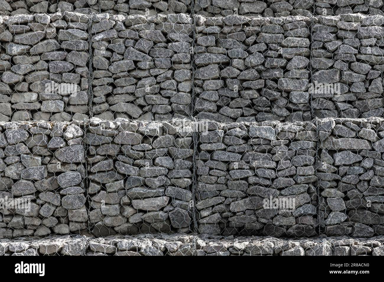 Struttura di un muro di gabione, gabbie d'acciaio riempite di rocce Foto Stock