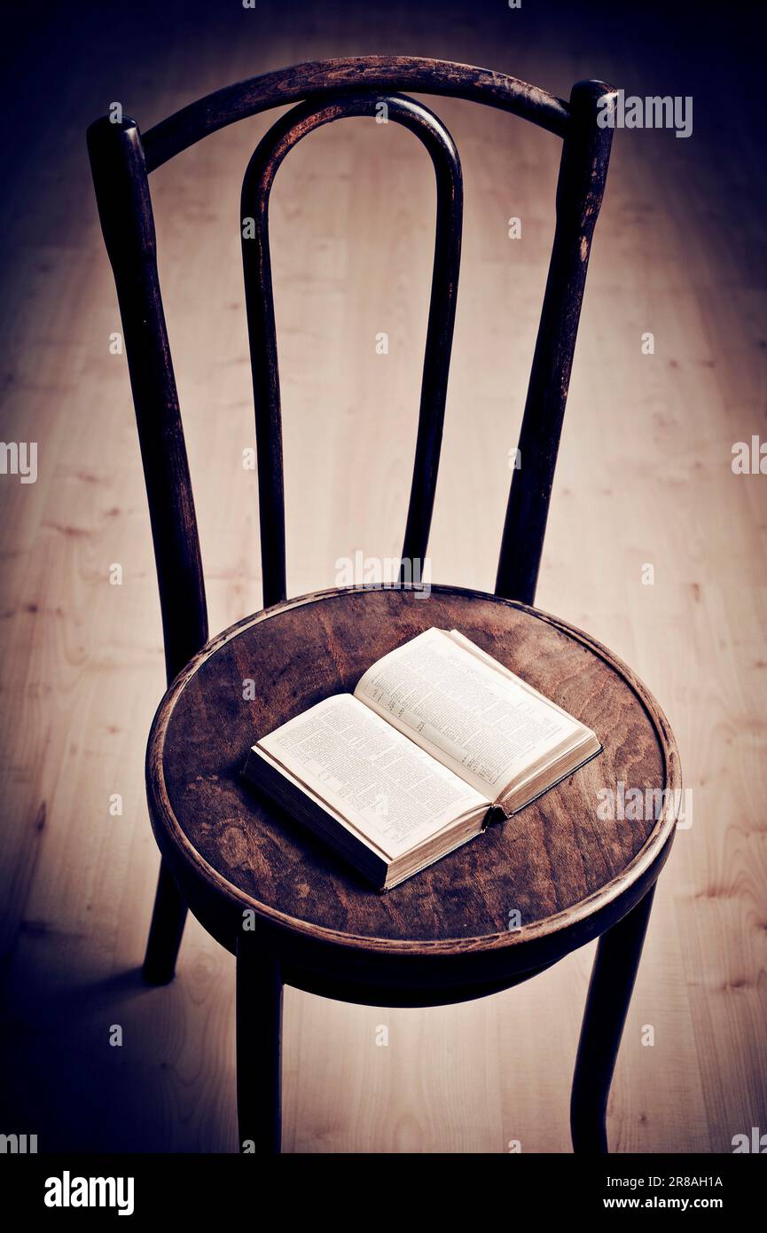 sedia in legno vintage con un libro aperto su di essa Foto Stock