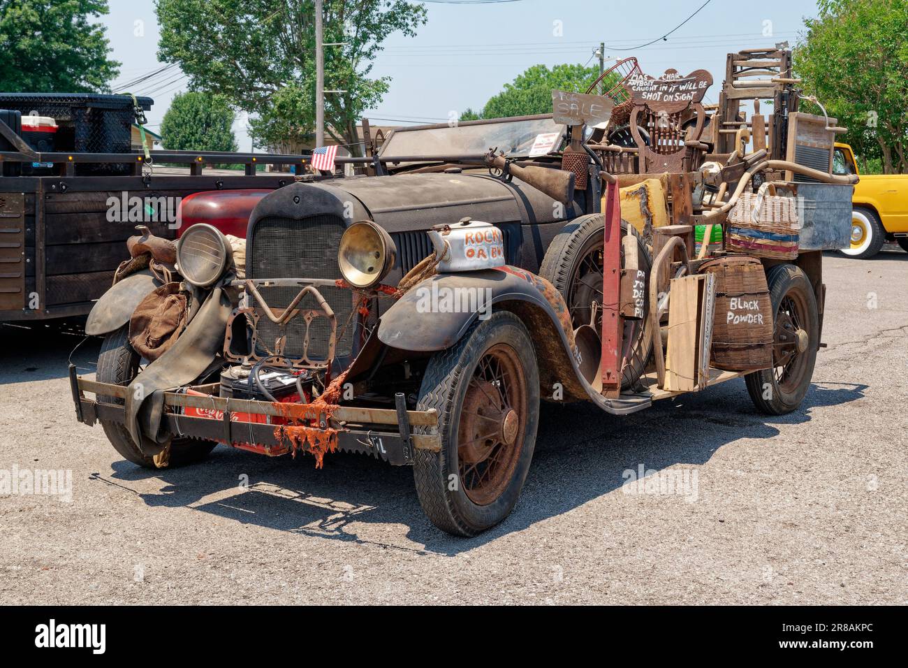 Una vecchia auto d'epoca si trasformò in un mobile collinare con un sacco di spazzatura attaccata tutto intorno al veicolo unico e creativo costruzione personalizzata vista in primo piano Foto Stock