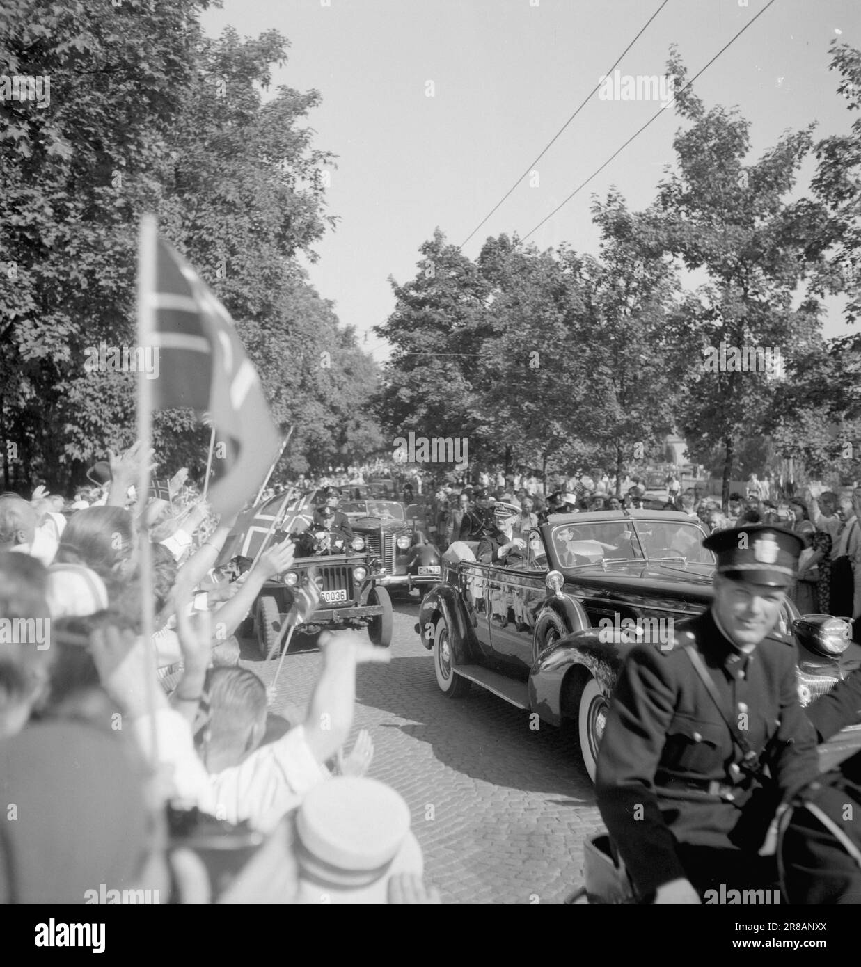 Attuale 16-1947: Centomila tributi al re per 75 anni Oslo aveva tirato fuori tutte le fermate per il 75th° compleanno del re Haakon il 3 agosto. L'immagine del re brillò contro uno in tutte le dimensioni ed edizioni da quasi ogni vetrina. Per tre giorni interi i festeggiamenti reali durarono. Il momento culminante dei festeggiamenti di Oslo è stato senza dubbio il giro in auto del re attraverso la città di domenica. La foto è stata scattata a Kirkeveien appena fuori dall'ospedale di Ullevål. L'intero trimestre è stato chiuso alla gente comune. Solo i residenti dell'ospedale, gli orfanotrofi e le case degli anziani sono stati ammessi Foto Stock