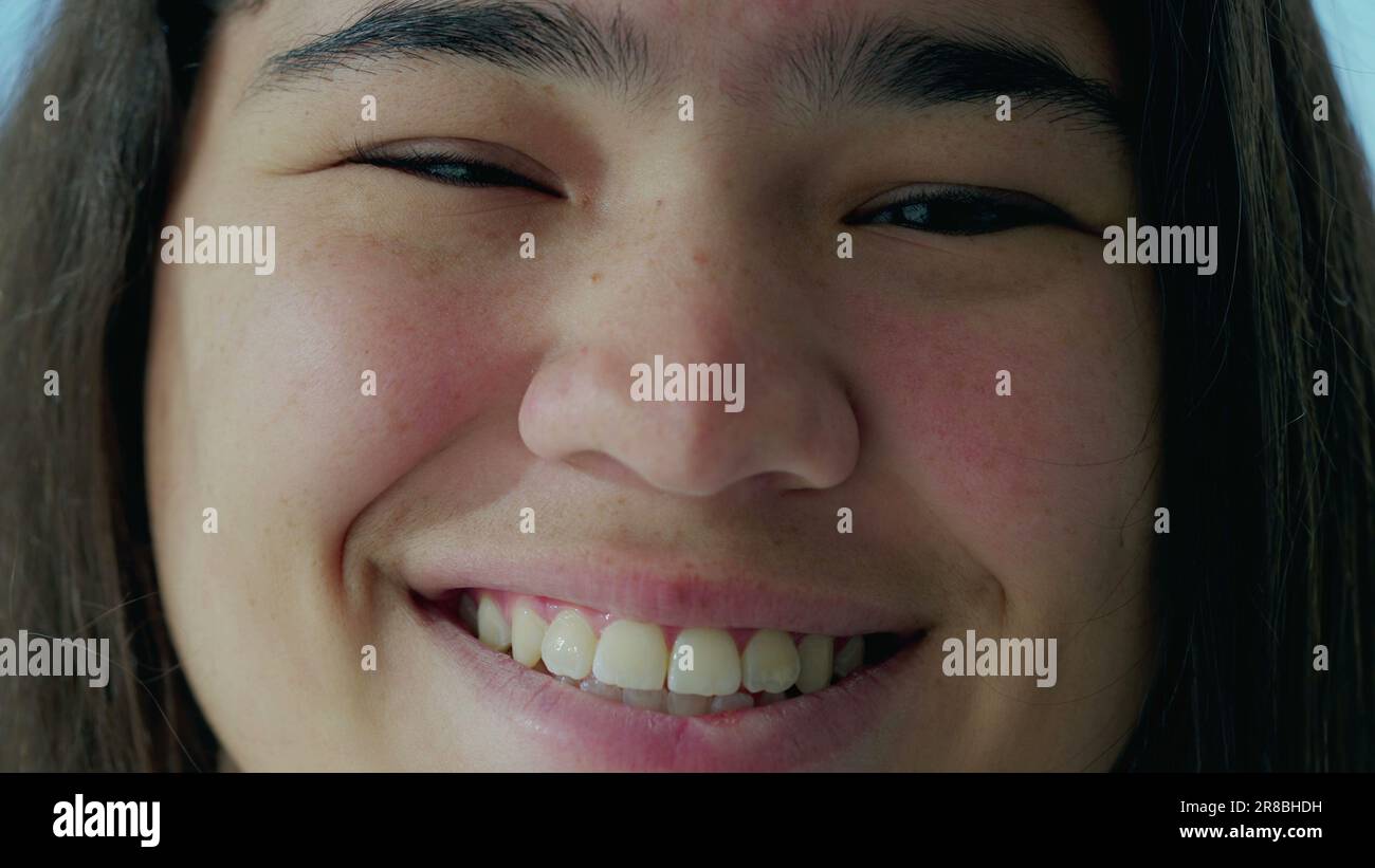 Occhi gioiosi della giovane donna asiatica, Macro Close-Up che rivela i dettagli in un sorriso femminile diverso. Crystal Clear Focus su un soggetto radiante nel suo 20s Foto Stock