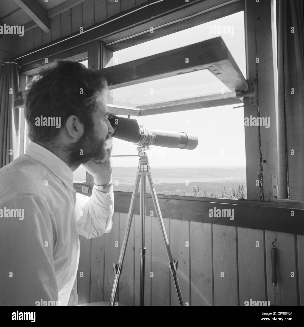 Attuale 29-6-1960: La sentinella solitaria abbiamo trovato un posto di lavoro strano. Giù là, un uomo che vive al suo posto cammina. Giorno e notte il nemico si aggirano, giorno e notte l'uomo solitario è in guardia - contro il fuoco della foresta. Stein Aanderaa, uno studente di teologia, ha un lavoro solitario di vacanza nella torre di guardia antincendio di Skgennungsåsen nelle foreste di Oslo. Alto e libero sopra le cime degli alberi, egli custodisce 5 miglia di foresta in tutte le direzioni. È in servizio 24 ore su 24. Foto: Aage Storløkken / Aktuell / NTB ***FOTO NON ELABORATA*** Foto Stock