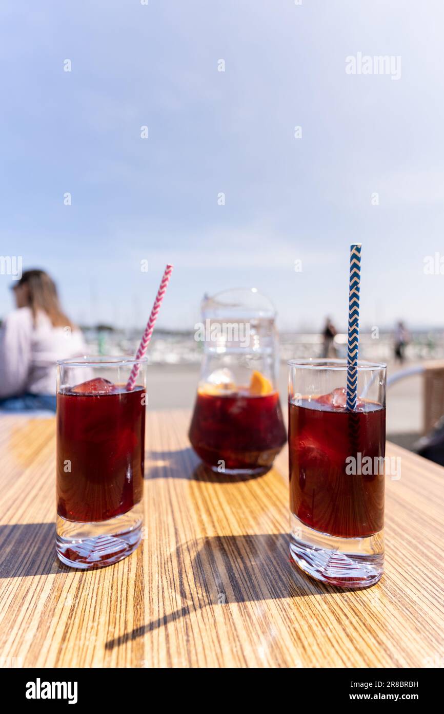Due bicchieri di sangria e una caraffa sul tavolo di una terrazza bar con il cielo blu per la copia spazio. Bevanda spagnola classica Foto Stock