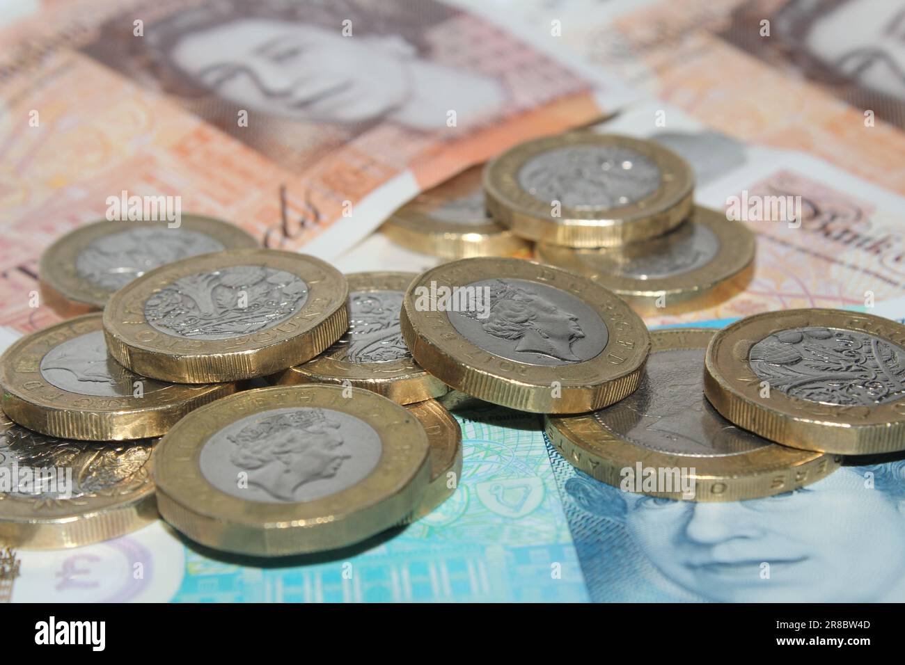Moneta britannica monete e banconote del regno sterlina da una sterlina monete e banconote da £ 10 sterline e £ 5 sterline primo piano Foto Stock