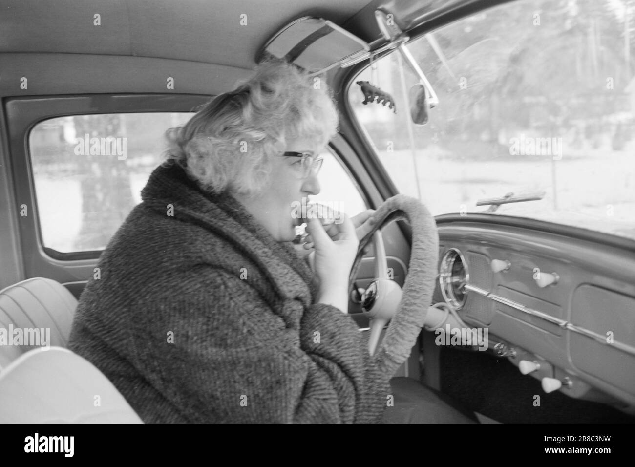 Attuale 55-8-1960: È una sfilata completa di successo Elisabeth Granneman non è più 'la casalinga cantata da Lørenskog'. Lei è un professionista dalla mattina presto alla notte tarda - reale alba-mattina presto... Un po' di cibo potrebbe avere un buon sapore, ma non ha il tempo di lasciare che accada il buon vecchio modo. Mangia un pasto leggero composto da un rollio al volante dell'auto durante il suo viaggio verso la Gramophone Conference con il direttore di reparto Berggren di Philips. Foto: Sverre A. Børretzen / Aktuell / NTB ***FOTO NON ELABORATA*** Foto Stock