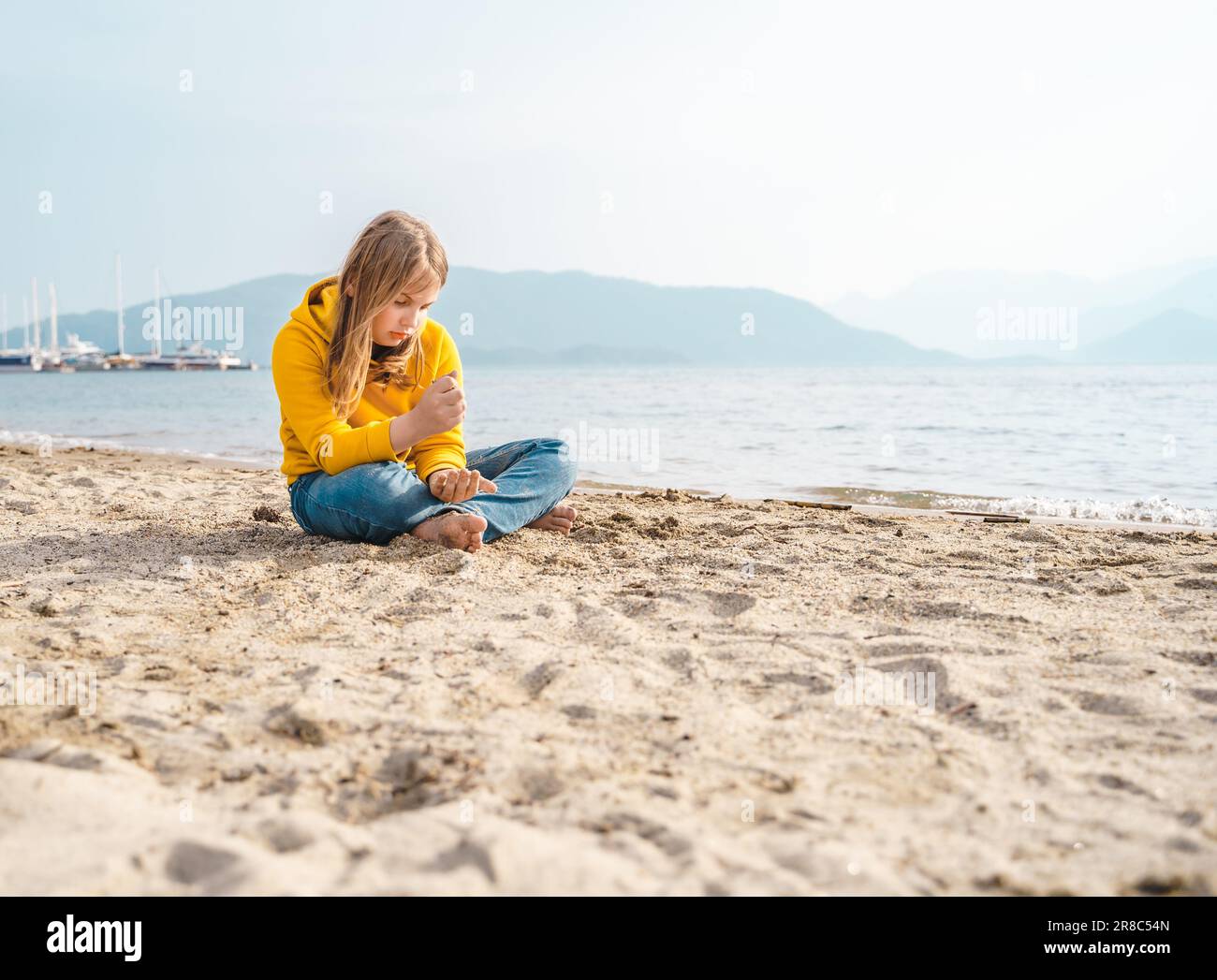 Solo bella ragazza triste adolescente siede pensieroso sulla spiaggia di sabbia. Sogni,ansia,preoccupazioni per il futuro,amici della scuola, genitori. Bullismo teen, ps Foto Stock