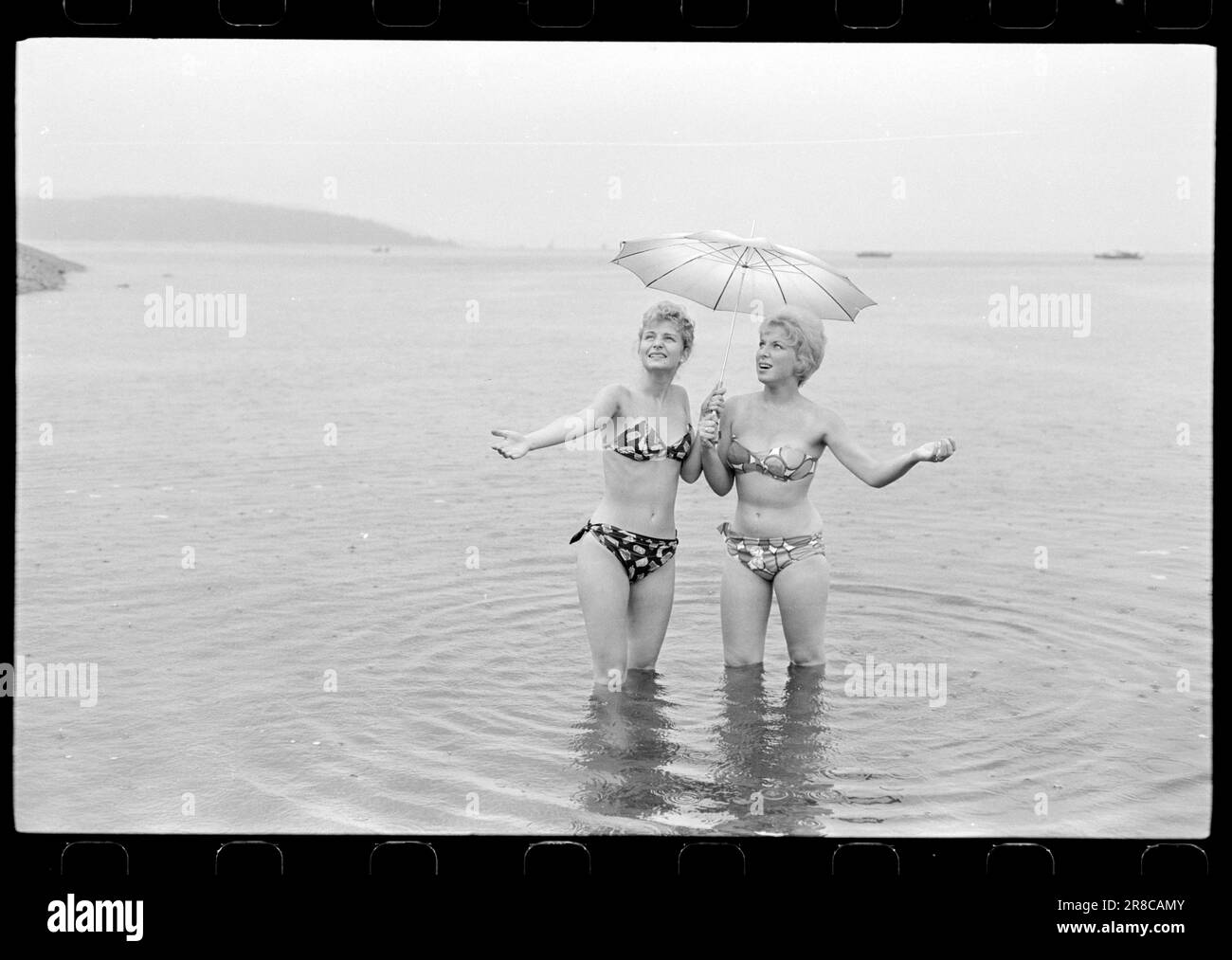 Attuale 33-5-1960: Marrone senza sole ora una nuova preparazione è disponibile per l'acquisto qui in Norvegia - un liquido che si striscio su in modo che si ottiene un abbronzatura durante la notte. Abbiamo fatto un esperimento e potete studiare i risultati nelle immagini. Dopo otto ore, la Marit oliata era dorata, ma aggiungiamo che si è rivelata un'abbronzatura costosa. Per il trattamento sono state utilizzate circa tre bottiglie, ciascuna delle quali costa 12 NOK. Era gocciolante e il sole era lontano dalle nuvole quando il primo cappotto fu posato alle 12. Marit (a sinistra) la voltò di nuovo a Brittan e la lasciò sola. Se la panacea mantenesse la sua promessa Foto Stock