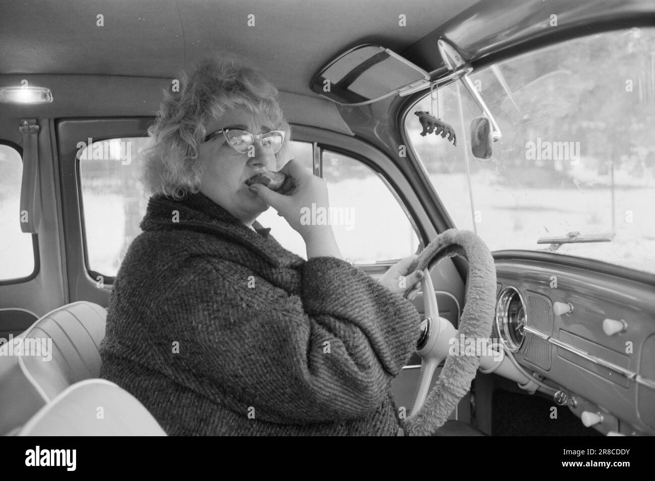 Attuale 55-8-1960: È una sfilata completa di successo Elisabeth Granneman non è più 'la casalinga cantata da Lørenskog'. Lei è un professionista dalla mattina presto alla notte tarda - reale alba-mattina presto... Un po' di cibo potrebbe avere un buon sapore, ma non ha il tempo di lasciare che accada il buon vecchio modo. Mangia un pasto leggero composto da un rollio al volante dell'auto durante il suo viaggio verso la Gramophone Conference con il direttore di reparto Berggren di Philips. Foto: Sverre A. Børretzen / Aktuell / NTB ***FOTO NON ELABORATA*** Foto Stock