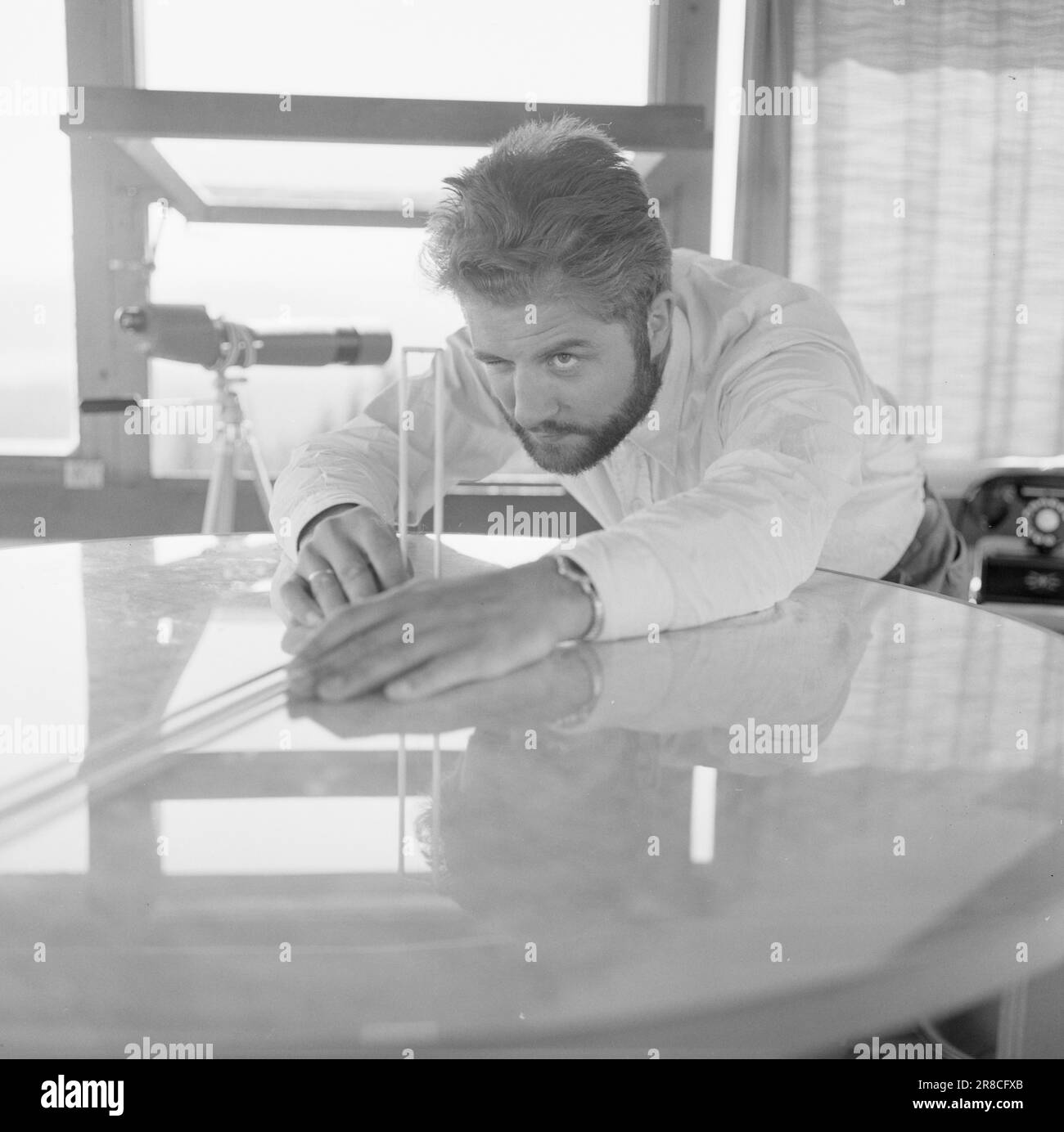 Attuale 29-6-1960: La sentinella solitaria abbiamo trovato un posto di lavoro strano. Giù là, un uomo che vive al suo posto cammina. Giorno e notte il nemico si aggirano, giorno e notte l'uomo solitario è in guardia - contro il fuoco della foresta. Stein Aanderaa, uno studente di teologia, ha un lavoro solitario di vacanza nella torre di guardia antincendio di Skgennungsåsen nelle foreste di Oslo. Alto e libero sopra le cime degli alberi, egli custodisce 5 miglia di foresta in tutte le direzioni. Al centro del pavimento nella sala di guardia, ha un tavolo con mappe e un dispositivo sonoro. È in servizio 24 ore su 24. Foto: Aage Storløkken / Aktuell / NTB ***FOTO NON IMA Foto Stock