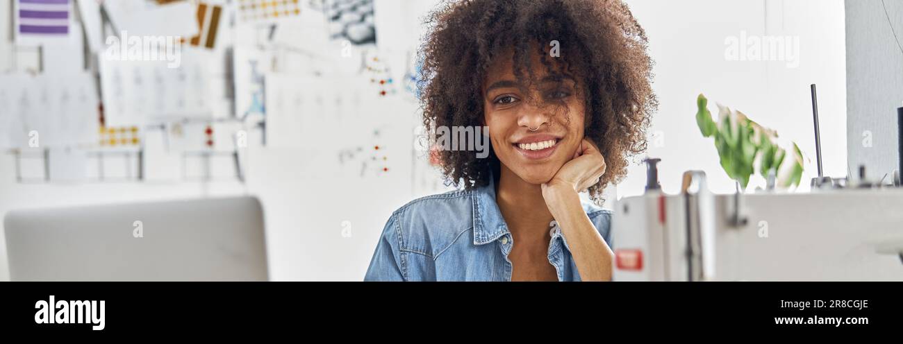 Dressaker afroamericano disegna guardare la lezione online via computer portatile in studio luce Foto Stock