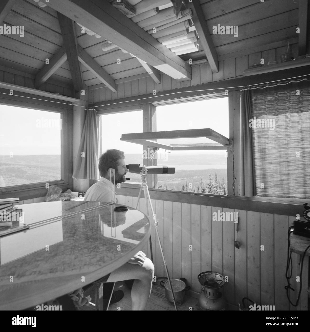 Attuale 29-6-1960: La sentinella solitaria abbiamo trovato un posto di lavoro strano. Giù là, un uomo che vive al suo posto cammina. Giorno e notte il nemico si aggirano, giorno e notte l'uomo solitario è in guardia - contro il fuoco della foresta. Stein Aanderaa, uno studente di teologia, ha un lavoro solitario di vacanza nella torre di guardia antincendio di Skgennungsåsen nelle foreste di Oslo. Alto e libero sopra le cime degli alberi, egli custodisce 5 miglia di foresta in tutte le direzioni. È in servizio 24 ore su 24. Foto: Aage Storløkken / Aktuell / NTB ***FOTO NON ELABORATA*** Foto Stock