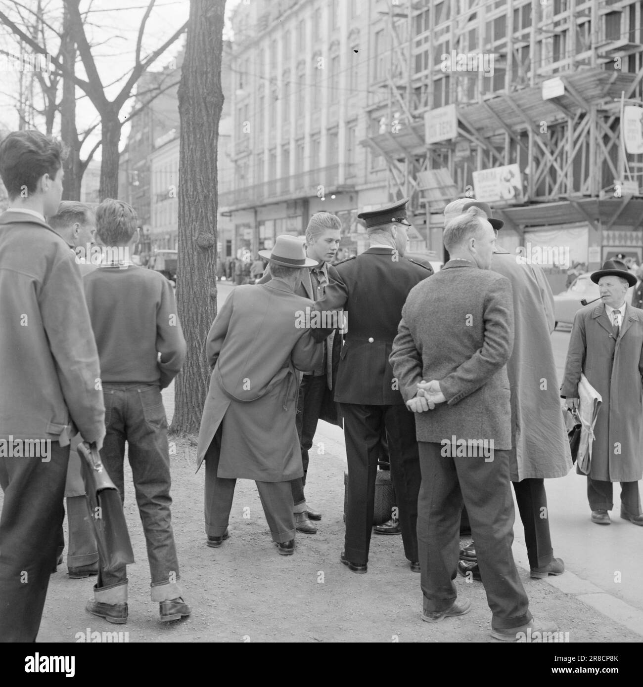 Attuale 25-1-1960: Dove l'impulso della città batte la fotocamera riflette la vita quotidiana in un angolo di strada a Oslo. Che cosa succede a un angolo di questo tipo? Questo gentiluomo vestito in modo impeccabile aveva probabilmente preso qualche goccia troppo presto - e poi la polizia è venuto... come chiamato. Foto: Aage Storløkken / Aktuell / NTB ***FOTO NON ELABORATA*** Corner Stortingsgata Rosenkrantzgate Foto Stock