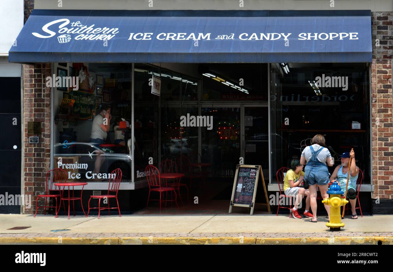 Una scena di strada candida nel centro di Bristol, Virginia, di tre clienti seduti fuori da un negozio di gelati e caramelle lungo la state Street della città. Foto Stock