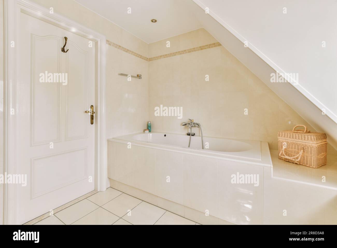 un bagno con vasca, lavandino e wc a rullo - in cima all'angolo della vasca da bagno si trova accanto alla porta Foto Stock