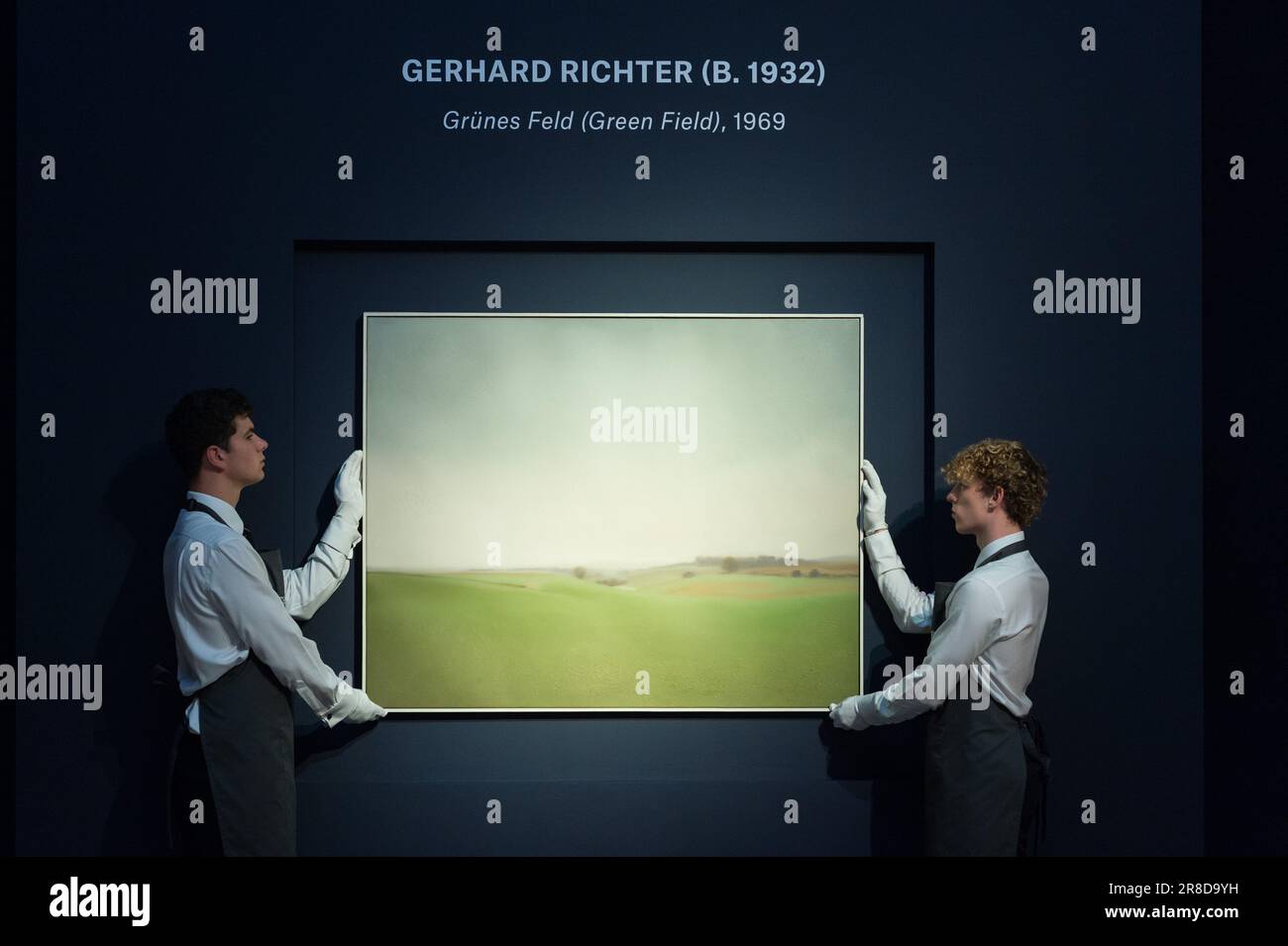 LONDRA, REGNO UNITO - 20 GIUGNO 2023: I gestori d'arte tengono un dipinto dal titolo ‘Grunes Feld (Green Field)’ di Gerhard Richter (est. £4.000.000 – 6.000.000) durante una fotocall alla casa d'aste di Christie che mostra i momenti salienti della serata di sale del 20th/21st secolo a Londra, Regno Unito il 20 giugno 2023. La serie d’aste Christie’s 20th/21st Century Art celebra i capolavori di oltre 100 anni di creatività e innovazione, presentati a giugno in quattro vendite online e live nel centro artistico internazionale di Londra. (Foto di Wiktor Szymanowicz/NurPhoto) Foto Stock