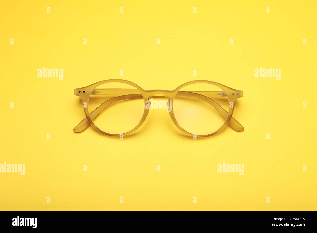 Occhiali con lenti correttive su sfondo giallo, vista dall'alto Foto Stock