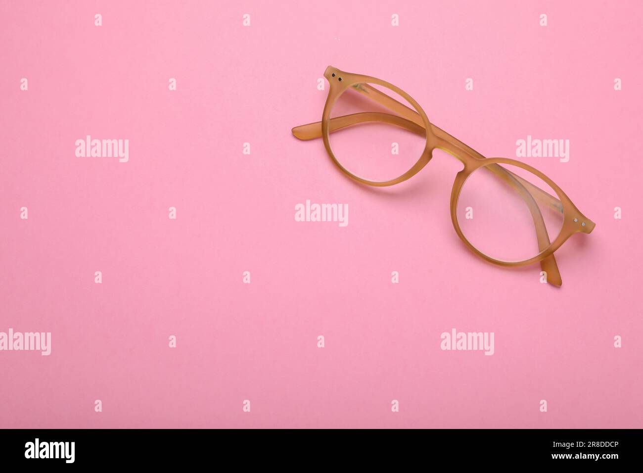 Occhiali con lenti correttive su sfondo rosa, vista dall'alto. Spazio per il testo Foto Stock