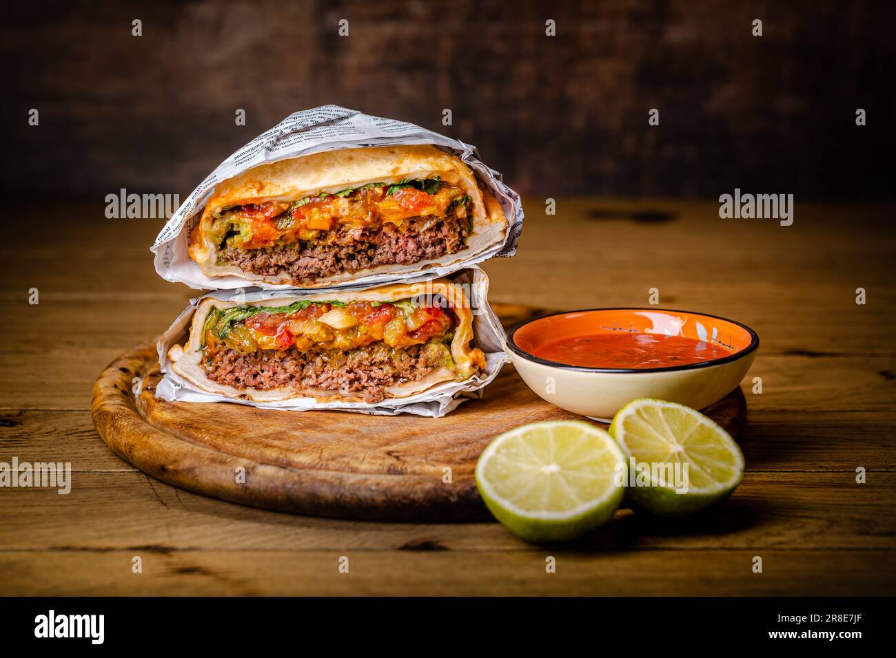 Hamburger o sandwich, torta di manzo con salsa e guacamole. Cucina messicana. Foto Stock