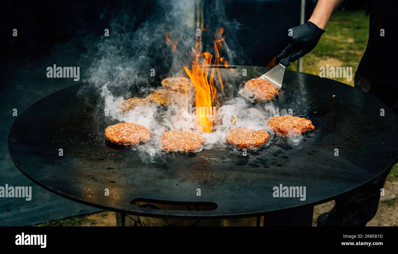 Preparare succosi polpette di hamburger di manzo . Carne barbecue sfrigolante sopra fiamme calde. Foto Stock