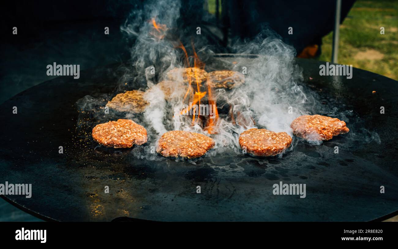 Preparare succosi polpette di hamburger di manzo . Carne barbecue sfrigolante sopra fiamme calde. Foto Stock