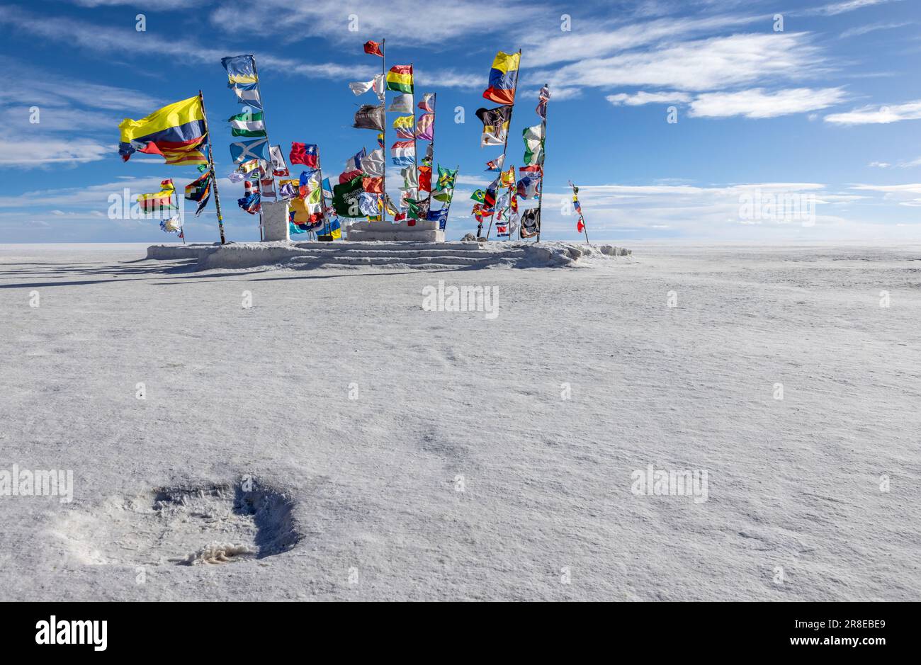 Bandiere internazionali colorate che sventolano sul Salar de Uyuni vicino al monumento Rallye Dakar a Uyuni, Bolivia, viaggiando ed esplorando l'Altiplano Foto Stock