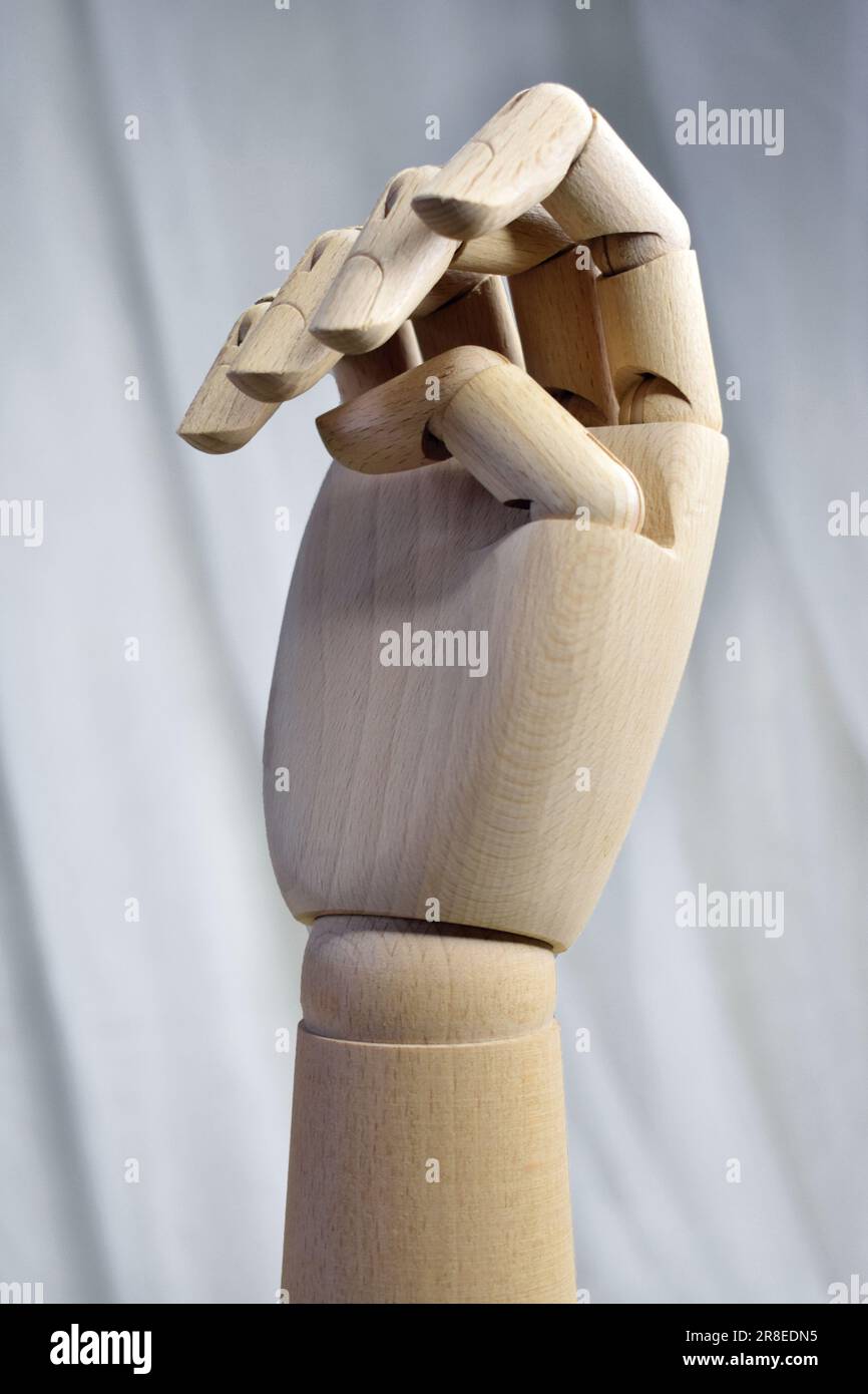 Una verticale di una mano di manichino in legno su sfondo bianco Foto Stock