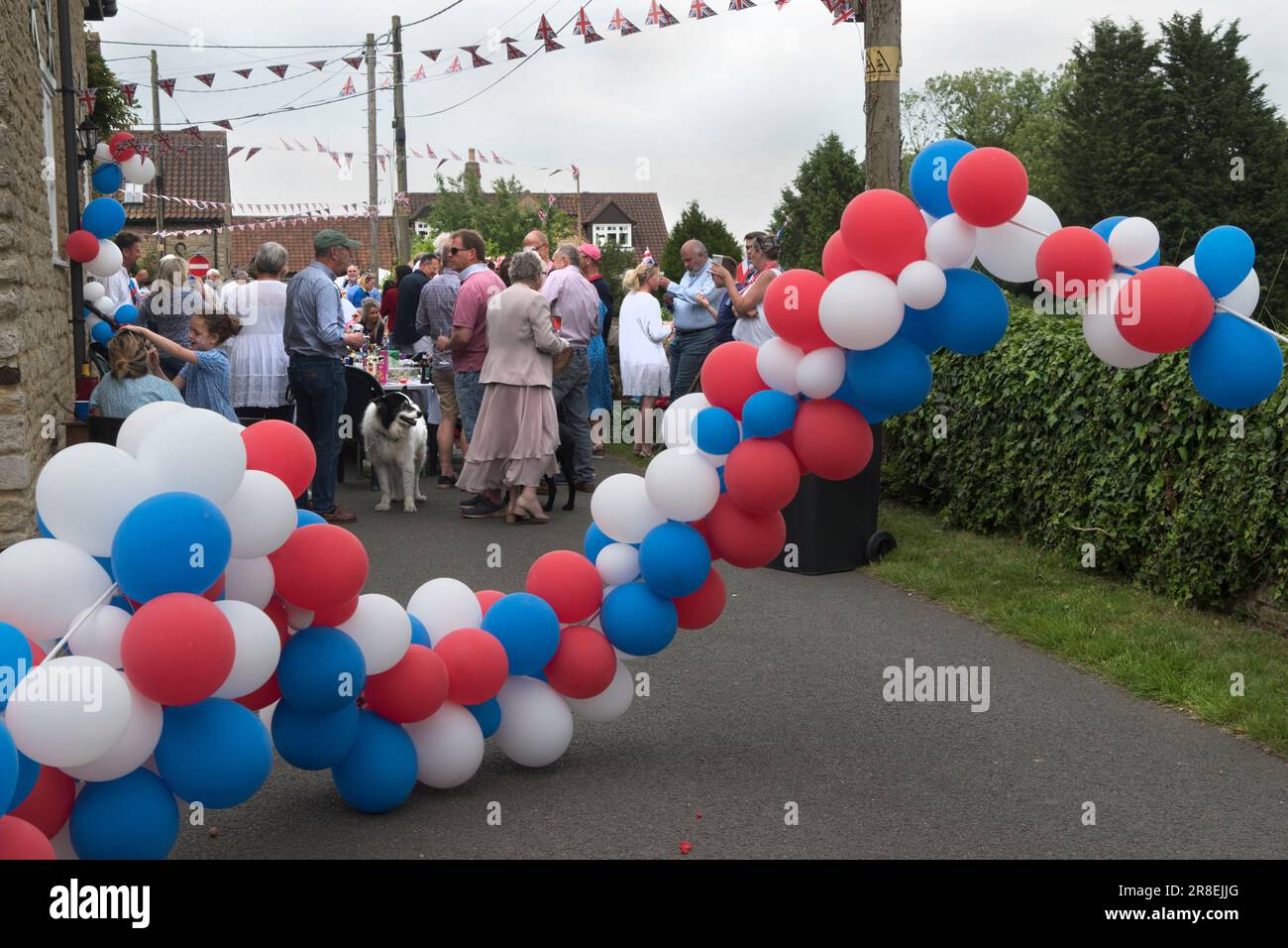 Palloncini rosso bianco e blu. Festa di strada del Giubileo di platino della regina Elisabetta II a Robbs Lane, Lowick. La strada era circondata da una serie di palloncini rossi, bianchi e blu. Agli abitanti del villaggio è stato chiesto di portare il loro cibo e alcuni da condividere. Vi parteciparono circa 50 persone. Lowick, Northamptonshire, Inghilterra, 3 giugno 2022. HOMER SYKES Foto Stock