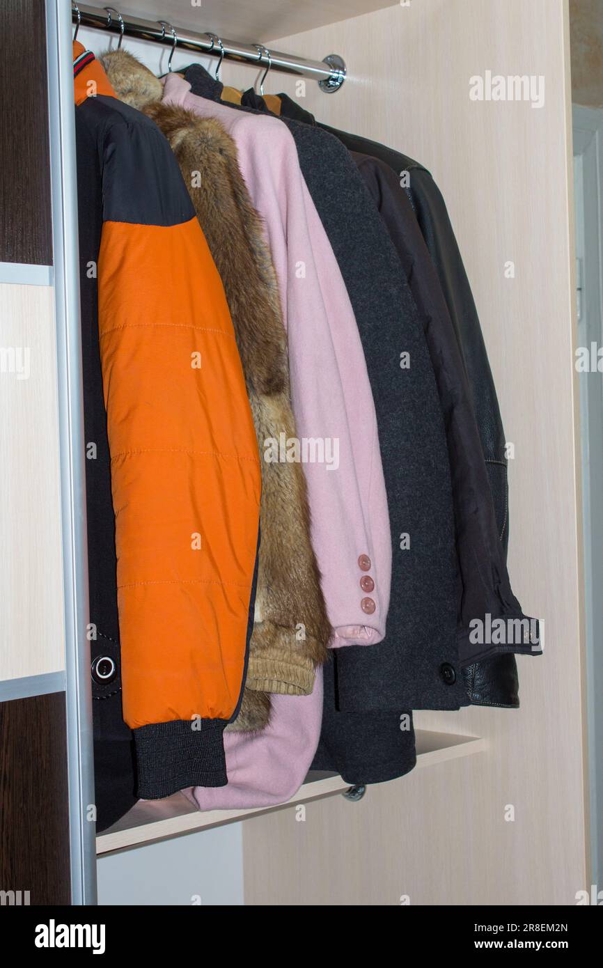 un armadio aperto con i vestiti invernali superiori in camera Foto Stock