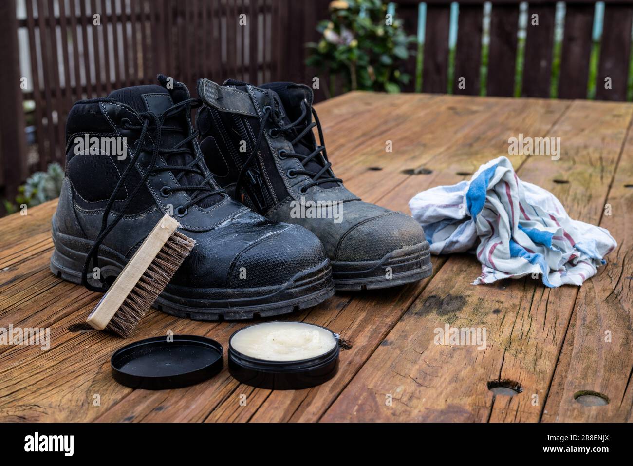 Coppia di stivali da lavoro in pelle che si abbellisce con una scialacca e una cera. Foto Stock