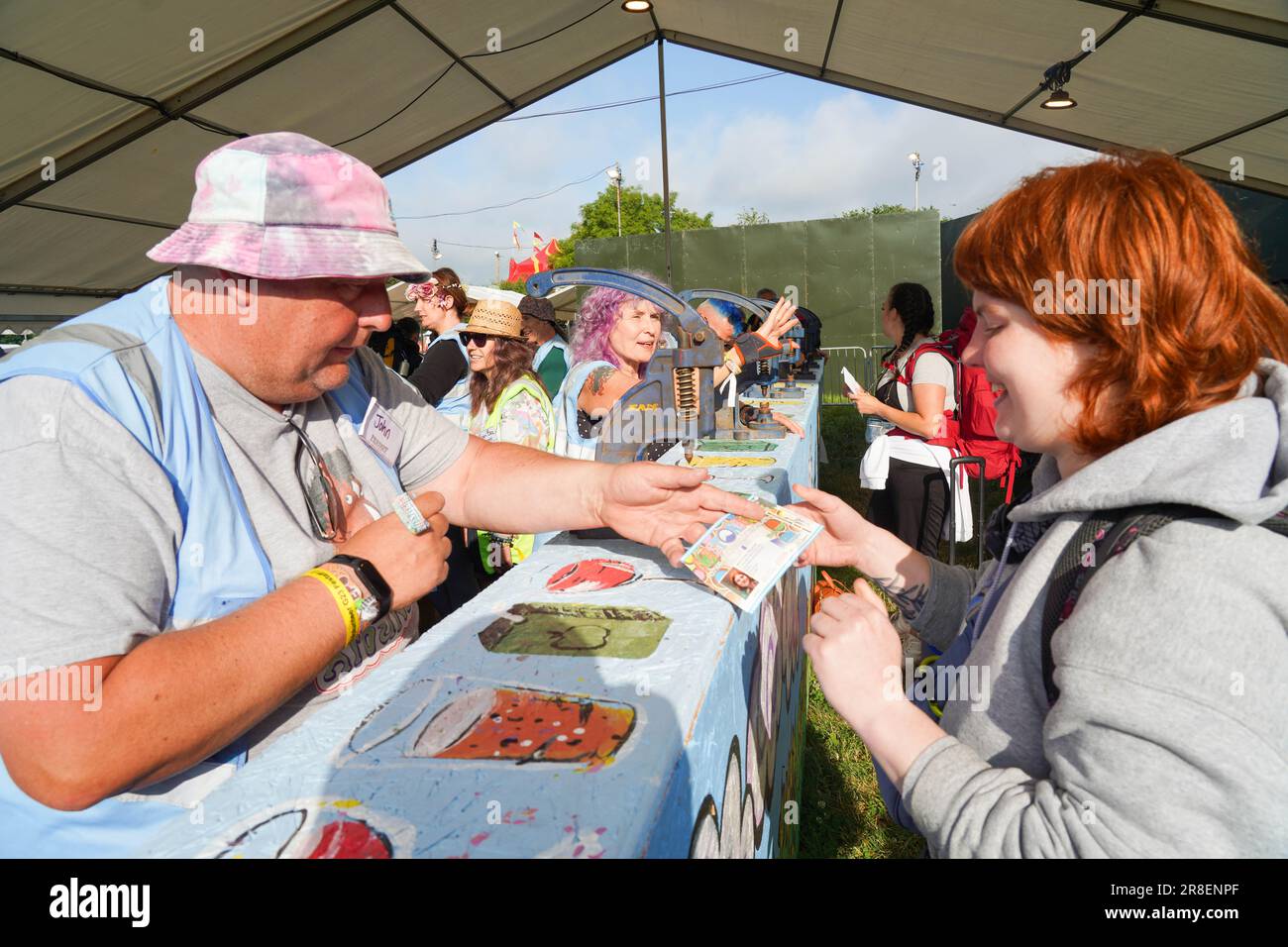Volontari che danno i primi arrivi al festival di Glastonbury 2023 i loro braccialetti ufficiali. Mercoledì 21 giugno, 2023. Foto: Richard Gray/Alamy Live News Foto Stock