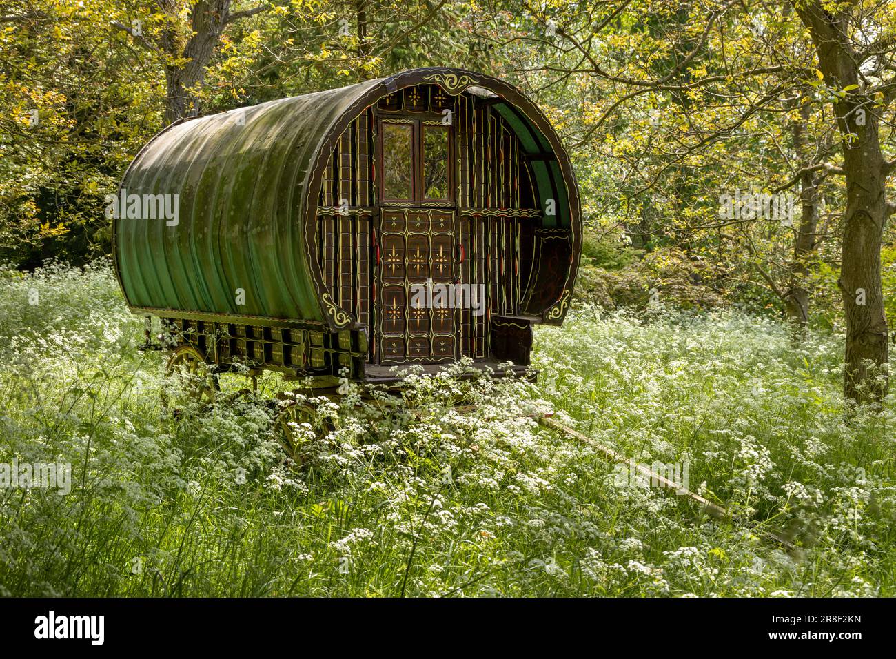 Vecchia carovana gitana situata in un bosco di fiori selvatici nel Gloucestershire, Inghilterra. Foto Stock