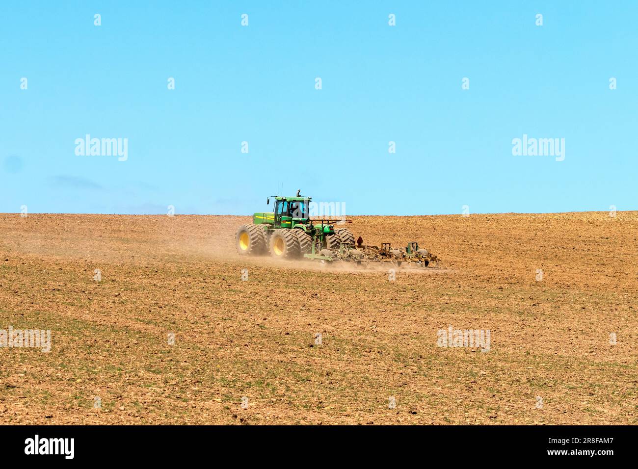 Agricoltore africano arare o coltivare terreni agricoli nel Capo Occidentale, in Sudafrica, utilizzando un'agricoltura verde e gialla John Deere Tractor Concept Foto Stock