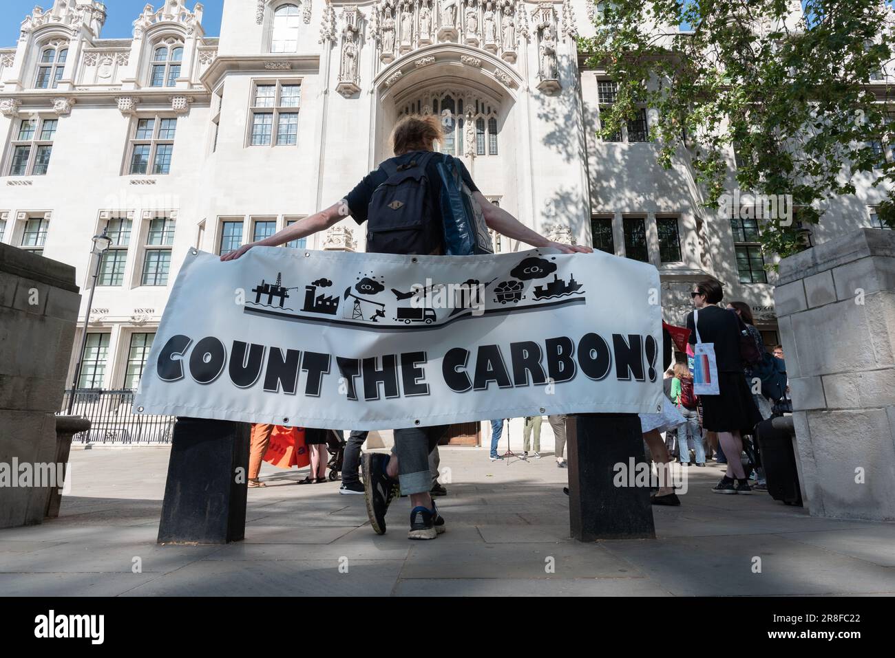 Londra, Regno Unito. 21 giugno, 2023. Un banner che dice "Conte the Carbon" è esposto al di fuori della Corte Suprema il primo giorno di audizioni di una sfida alla decisione di consentire la perforazione di petrolio a Horse Hill, Surrey. La sfida, sostenuta da una coalizione tra cui il Weald Action Group e Friends of the Earth, afferma che le decisioni di pianificazione devono tenere conto delle emissioni di carbonio 'correnti' e, se consentito, gli attivisti ritengono che possa avere un impatto significativo sulle future decisioni sull'estrazione dei combustibili fossili. Credit: Ron Fassbender/Alamy Live News Foto Stock