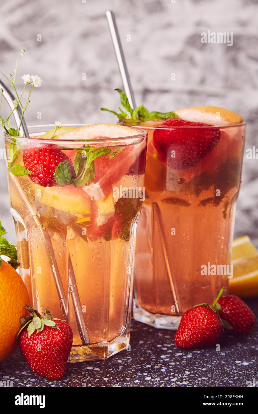 Cocktail analcolico di agrumi sani con agrumi e fragole. Detox vitaminizzato acqua infusa sana. Foto Stock