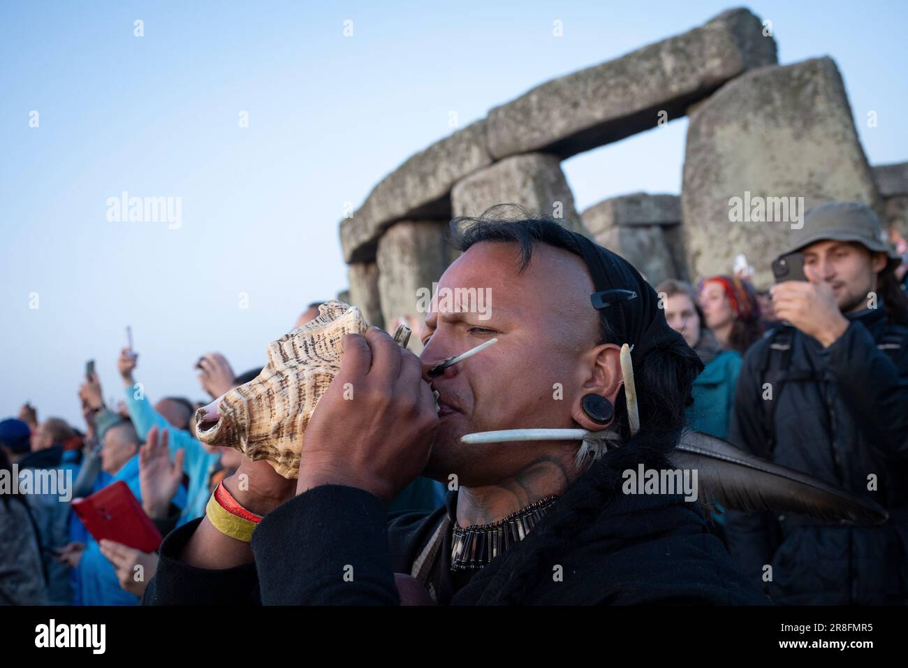 I festeggiatori spiritualmente attenti celebrano il Solstizio d'estate (metà estate e giorno più lungo) presso le antiche pietre tardo-neolitiche di Stonehenge, il 21st giugno 2023, a Wiltshire, Inghilterra. Il solstizio d'estate è il giorno più lungo dell'emisfero settentrionale e la notte più breve dell'anno, quando l'asse della terra è inclinato nel suo punto più vicino al sole e i pagani dicono che l'antico monumento è un luogo sacro che collega la Terra, la Luna, il Sole e le stagioni. Stonehenge fu costruita in tre fasi tra il 3.000 a.C. e il 1.600 a.C. Stonehenge è di proprietà del patrimonio inglese che dice che 8.000 visitatori sono stati ammessi nel Foto Stock