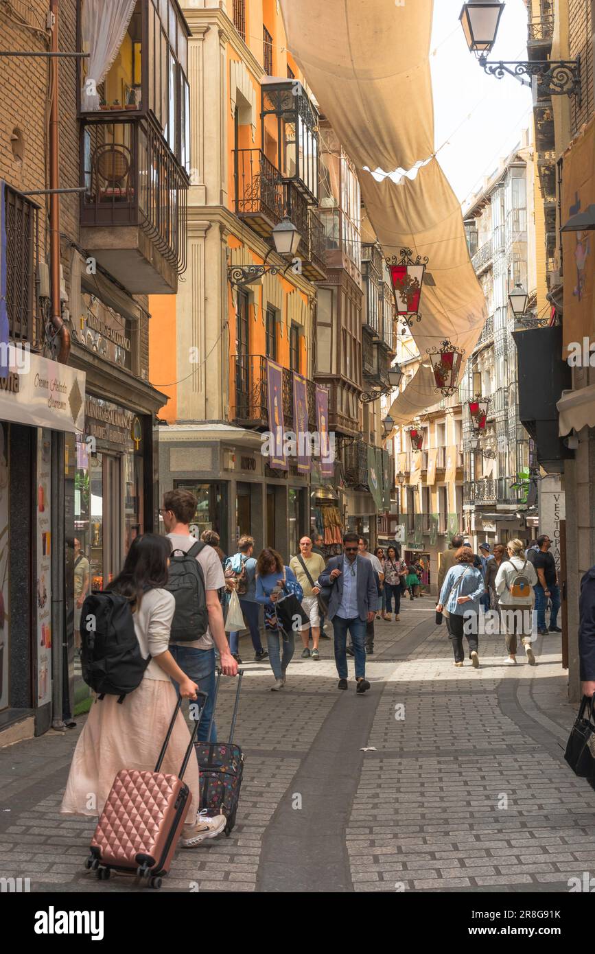 Vacanza Spagna, vista posteriore in estate di due giovani che viaggiano in valigia nella Calle commercio nella storica zona del centro storico di Toledo, Spagna Foto Stock