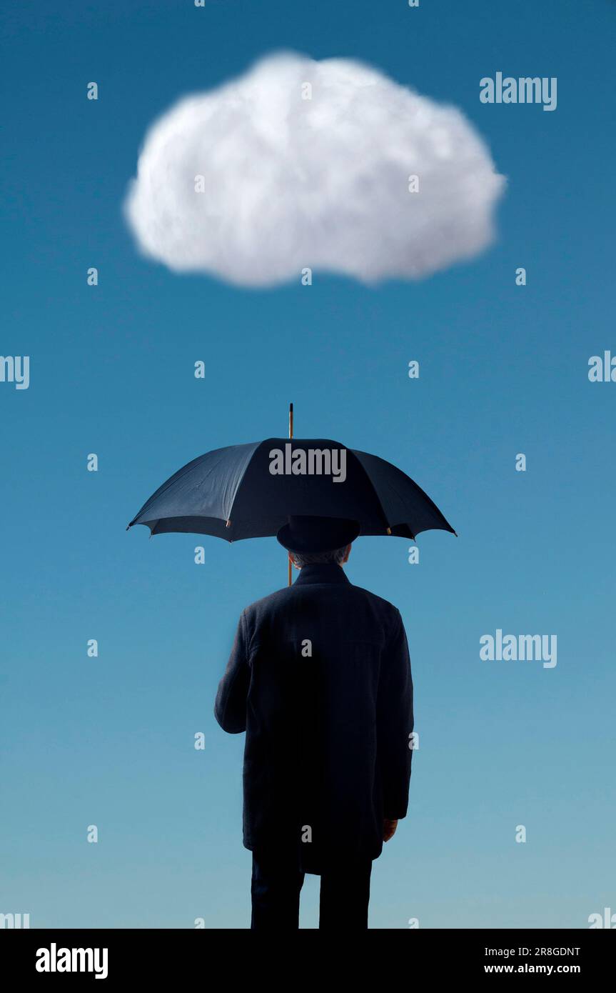 uomo che indossa un abito e un cappello, tenendo un ombrello sotto una nuvola bianca Foto Stock