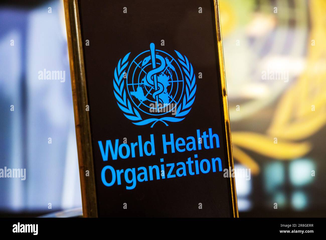 Immagine del simbolo: Smartphone con logo DELL'OMS (Organizzazione mondiale della sanità) su sfondo sfocato Foto Stock