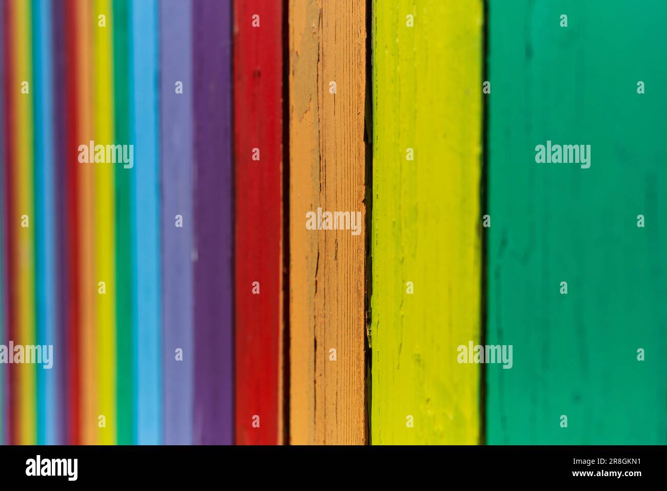 Una vecchia recinzione dipinge colori brillanti per creare un motivo audace. Foto Stock
