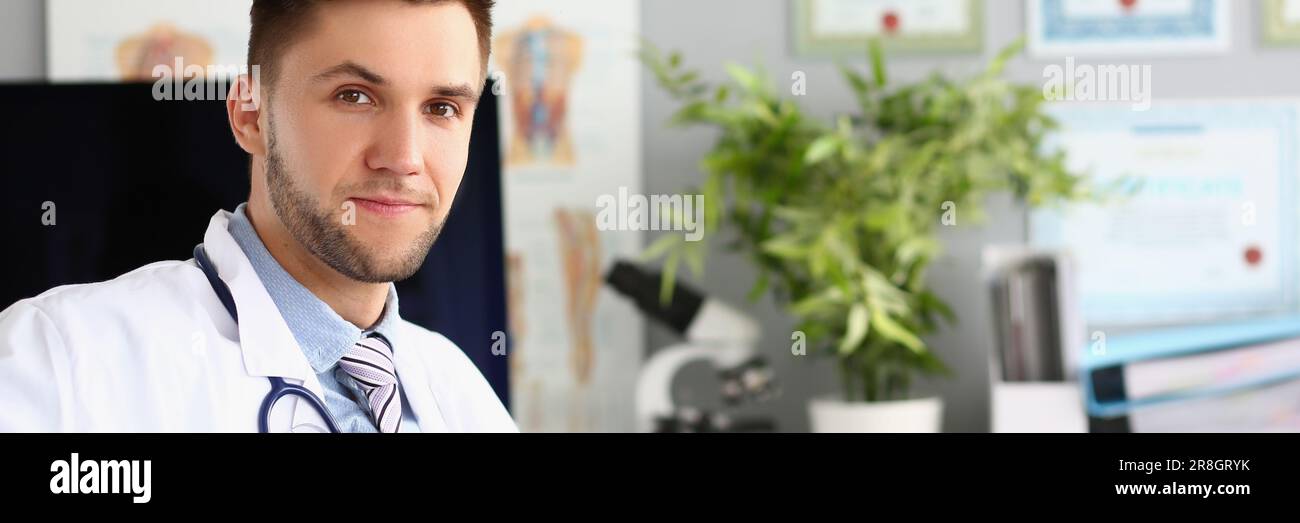 Ritratto di giovane medico siede in clinica ufficio Foto Stock
